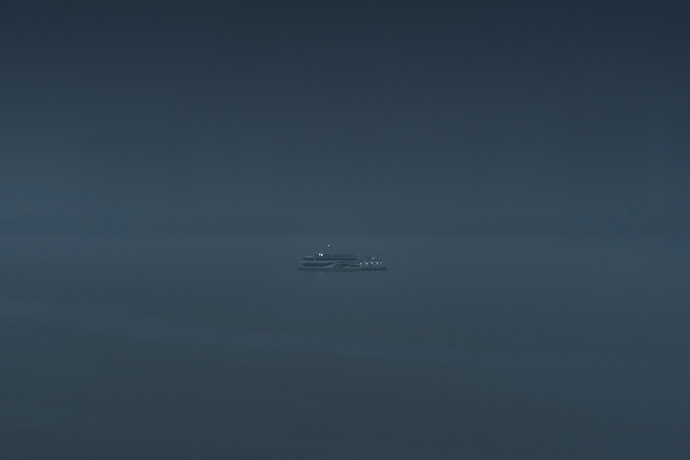 a small boat floating across a dark ocean