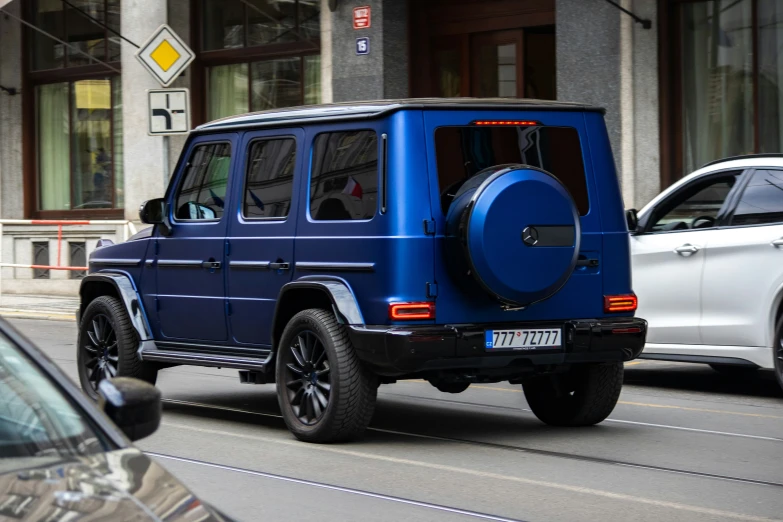 a blue jeep driving down a street with traffic