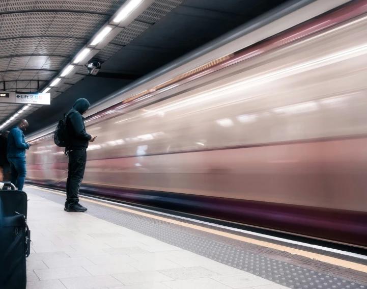 two people on a platform with luggage next to them