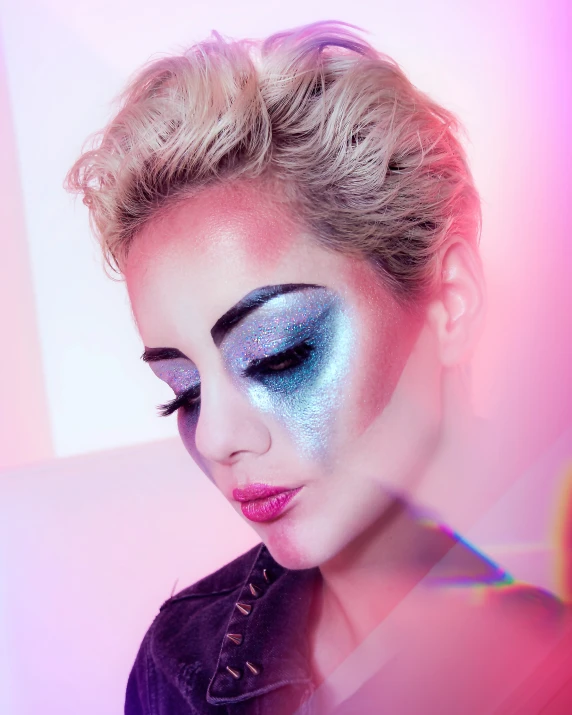 a woman with a make up on her face and blue eyeshadow, and hair