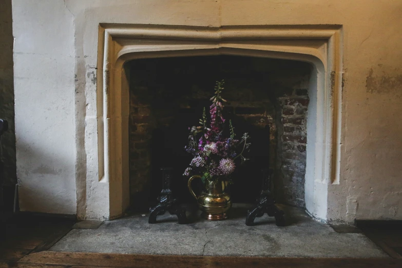 vase with flowers inside of an old fireplace