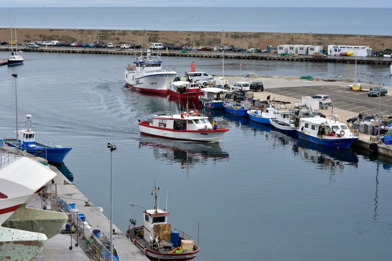 several boats sit parked at a marina with water in the foreground