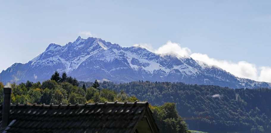 the mountain peaks over houses below the clouds