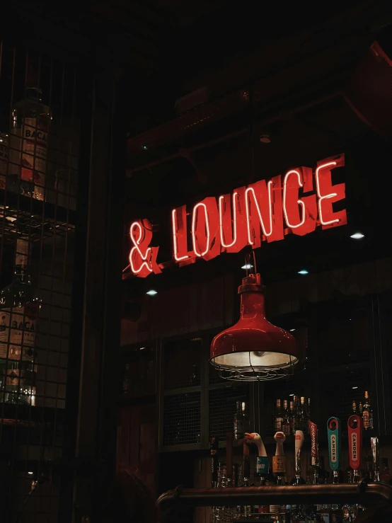 a red and white sign for lounge and lounge in a dark area