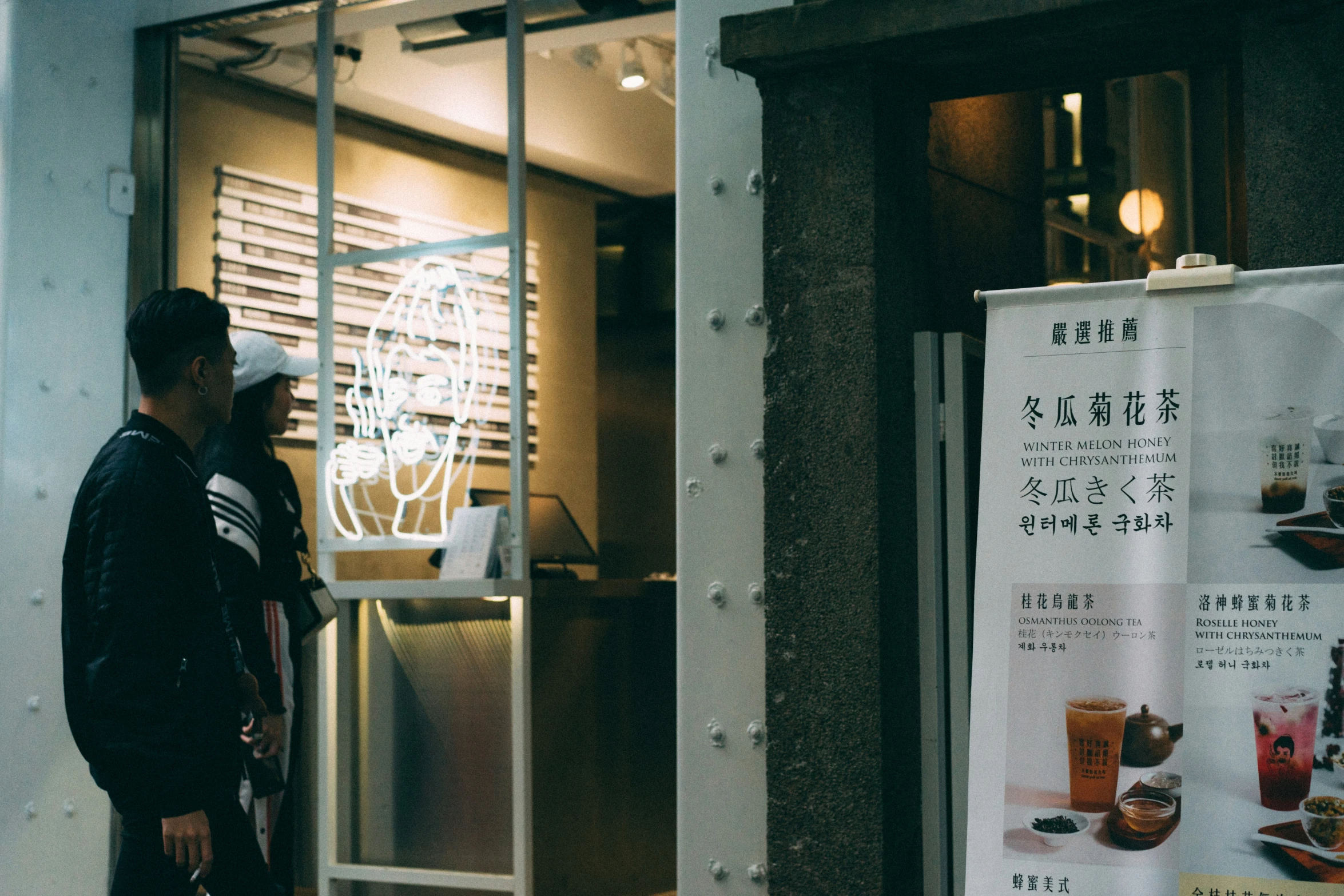 two men standing outside a store looking in the window