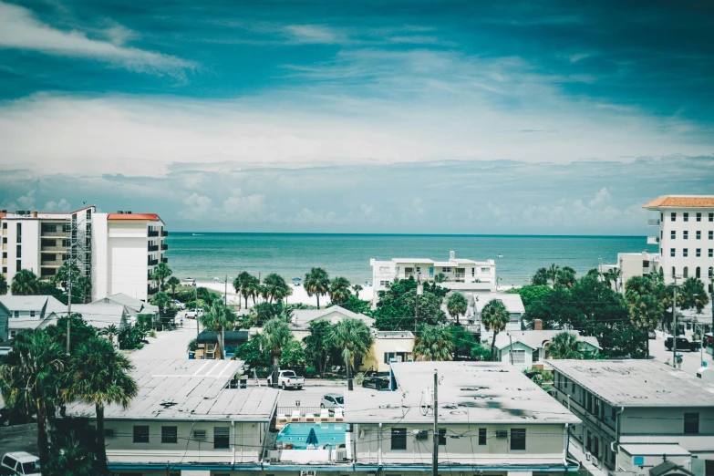 a cloudy blue sky shows buildings and water and ocean