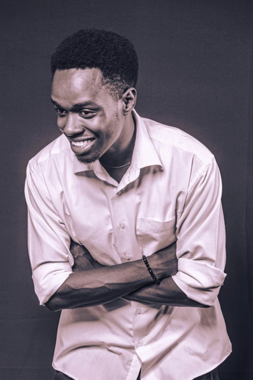 a man in white shirt smiling while leaning on a chair