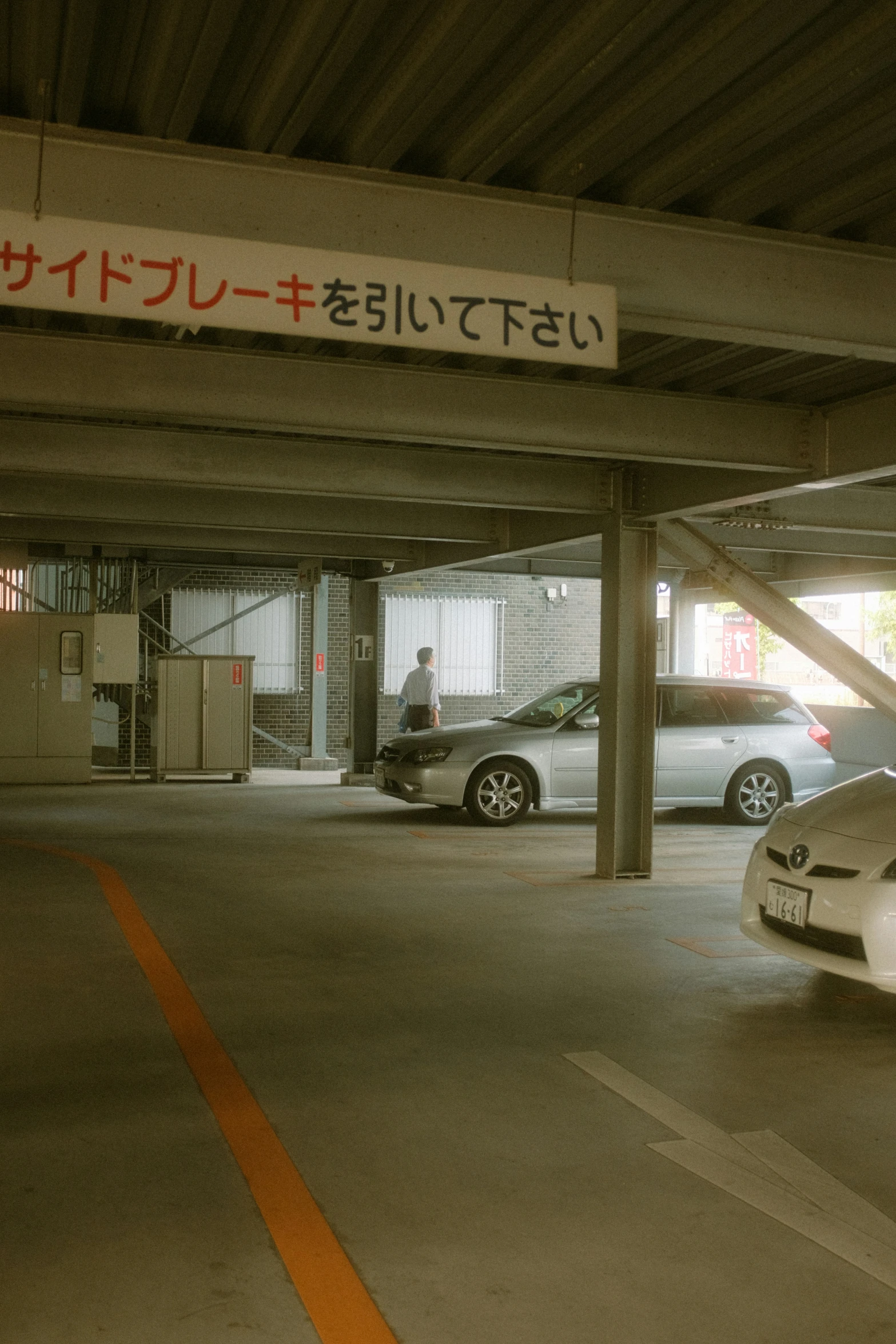 two cars parked in a parking garage under an awning