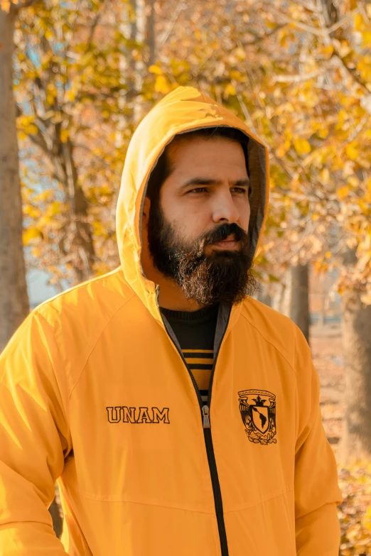 a man wearing yellow and black jacket in forest