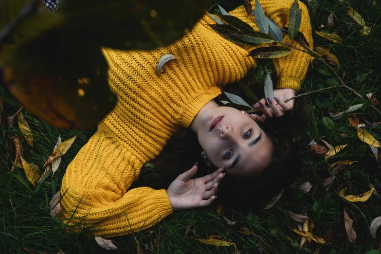 a woman laying on her side in a field