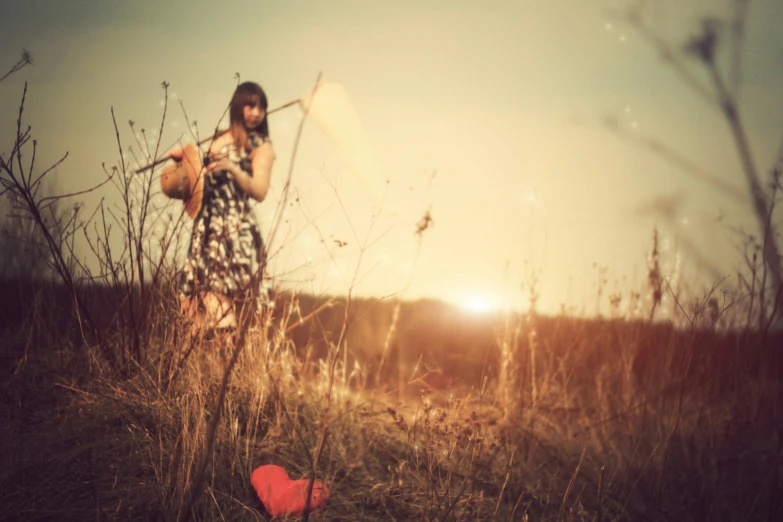 a woman is in a field with a kite