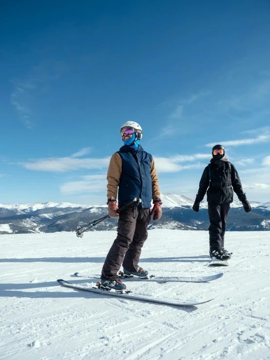 two people on snowboards are standing on the slope