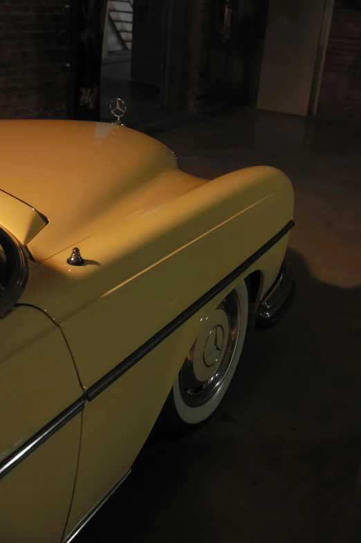 a tan classic car parked in a garage