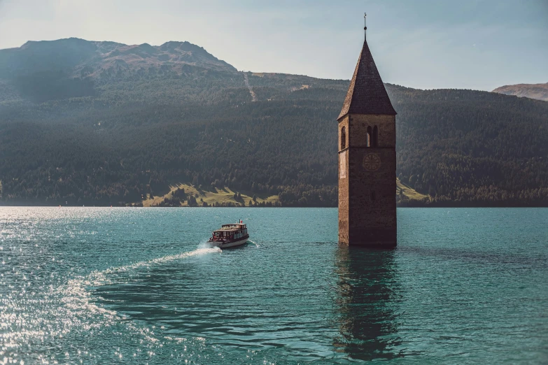 a boat drives near an old tower in the water