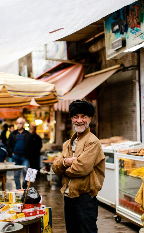 the man is walking down the street smiling for the camera