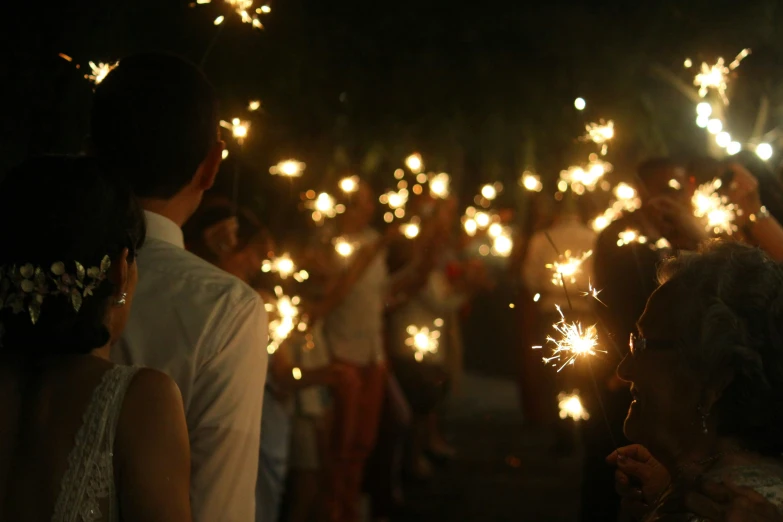 a group of people holding lit sparklers in their hands