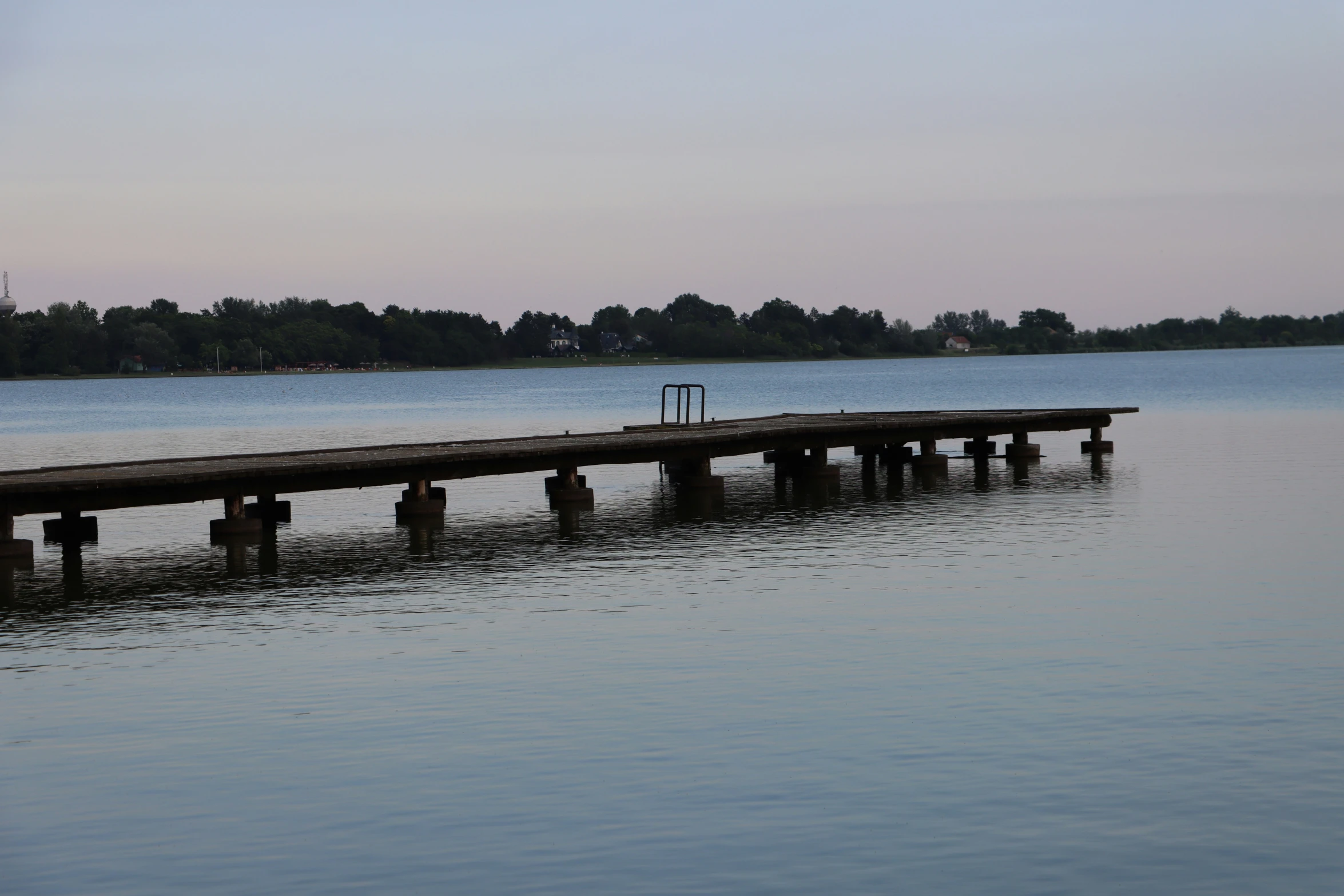 there is a dock in the water near some trees