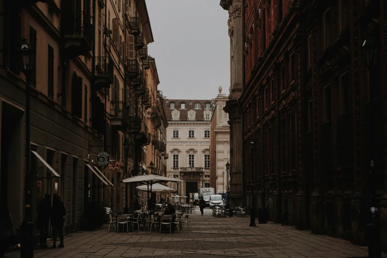 people sitting at tables near the tall buildings on the street