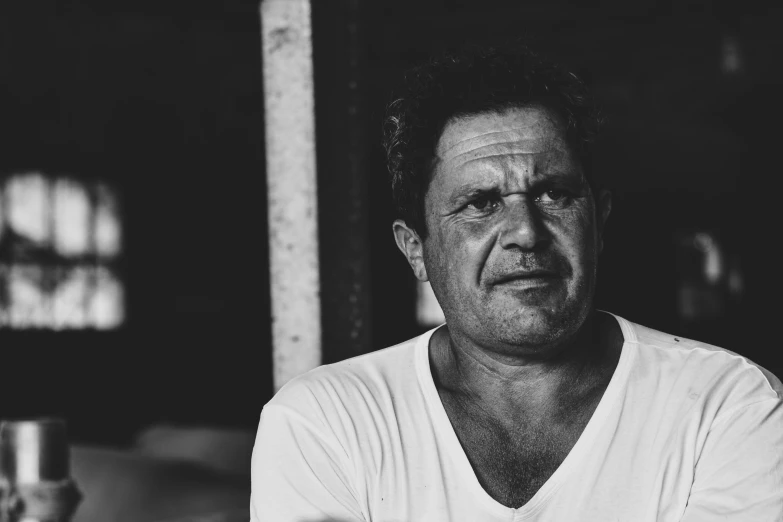 a man looking sad while sitting in front of a bar