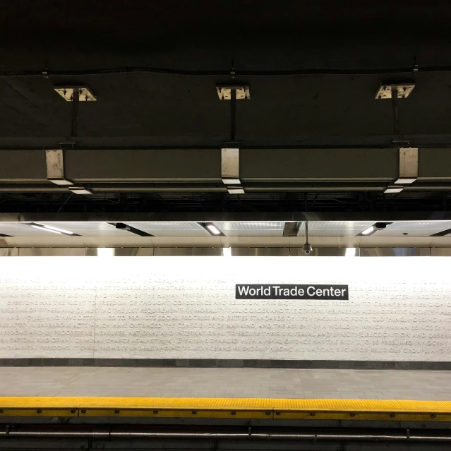 a train station platform with signs and tracks on the platform