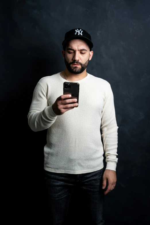 a man wearing a hat and using his cell phone