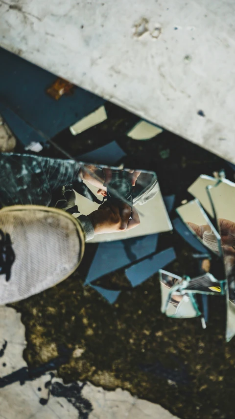 the reflection of someones feet and foot sitting on a broken mirror