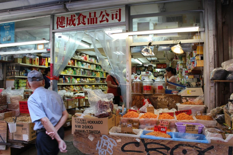 people walking around an outdoor market with lots of boxes of food