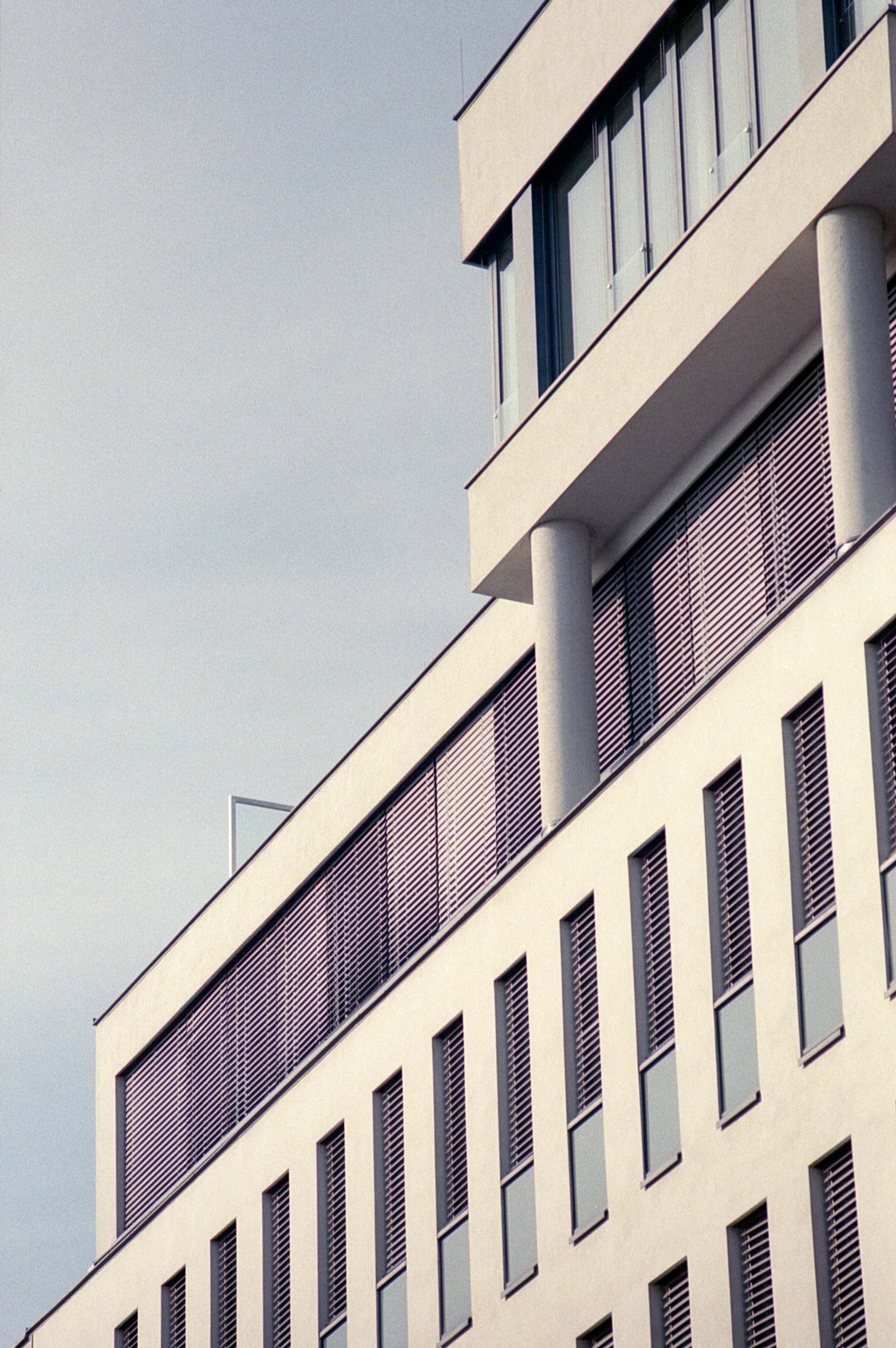 a white building with shutters at the top