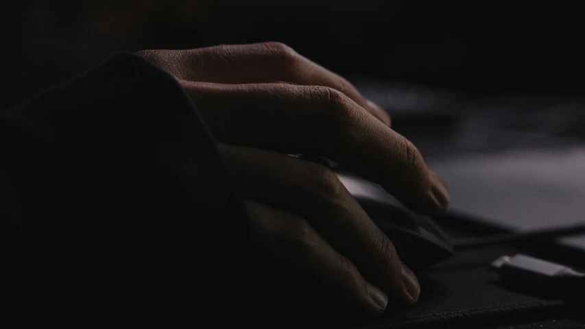 a hand is typing on a keyboard in the dark