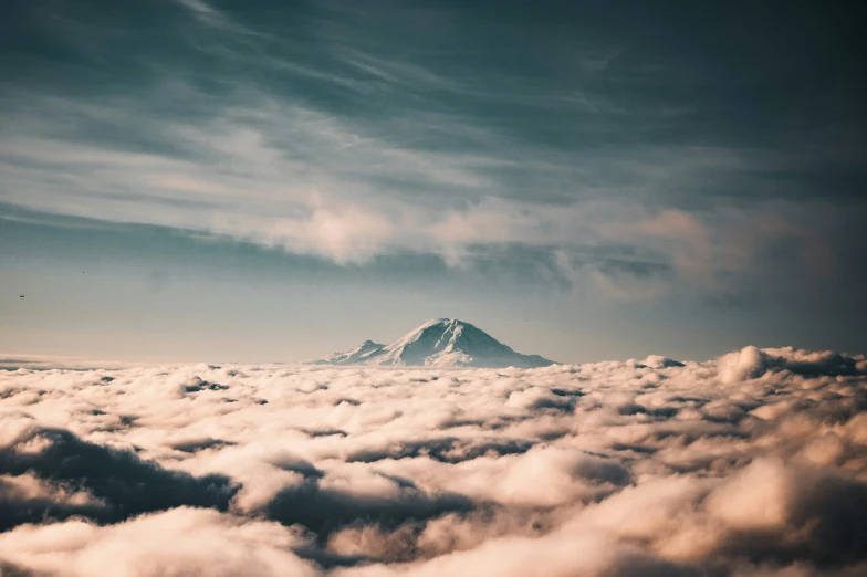 the view of a cloud covered mountain from a plane