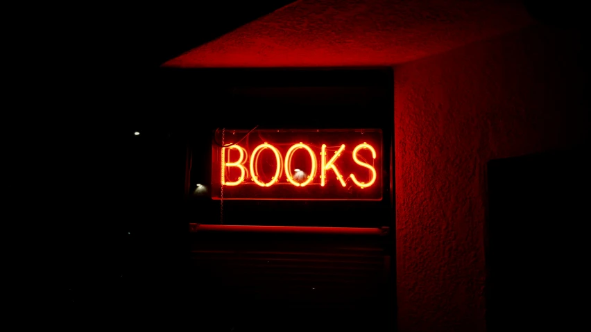 an open book shop sign in the dark