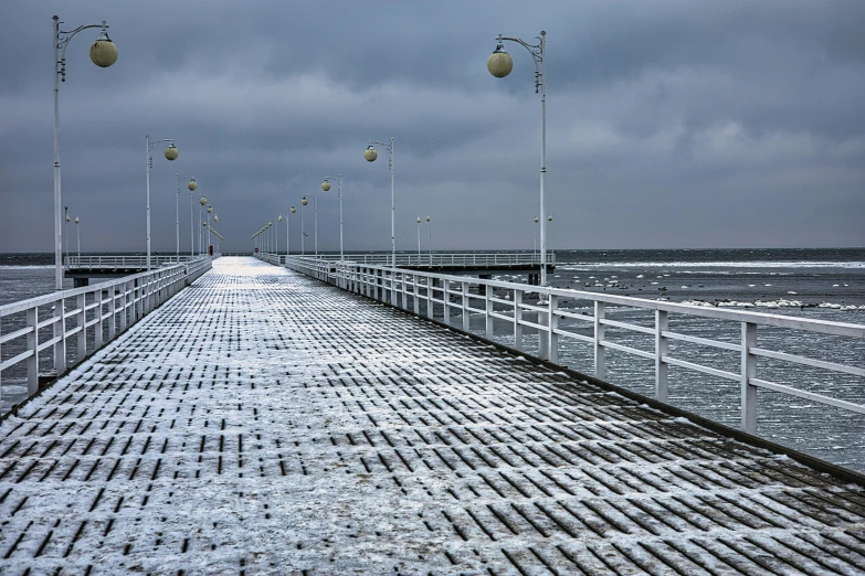 a dock on the edge of water with many lights in it