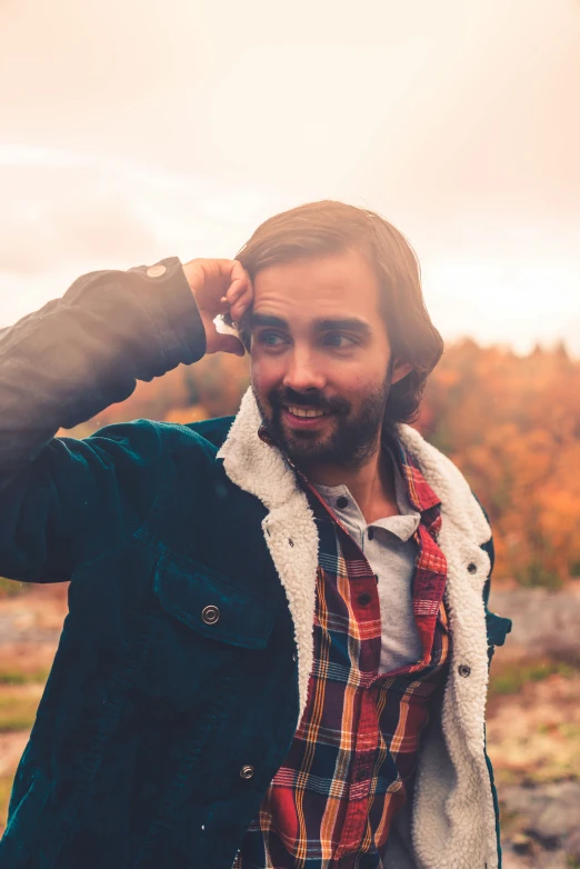 a man with beard and coat in a field