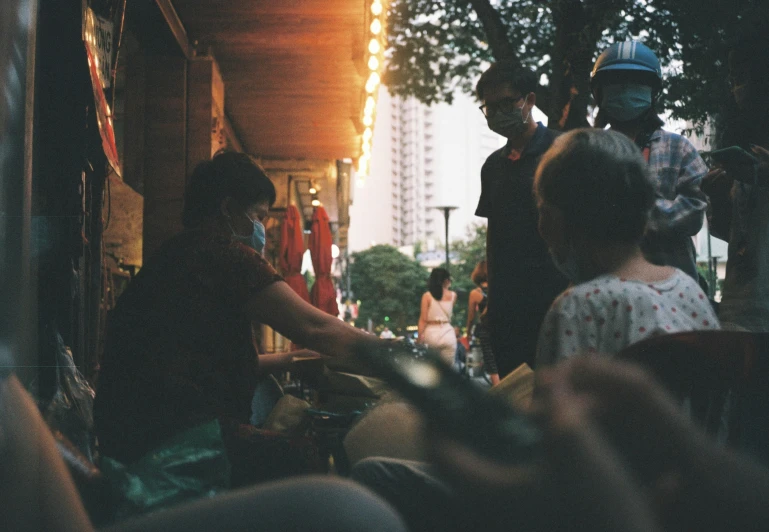 a group of people standing around a table full of food