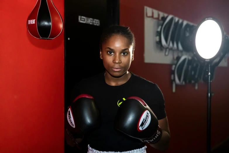 a black woman in a boxing uniform is posing