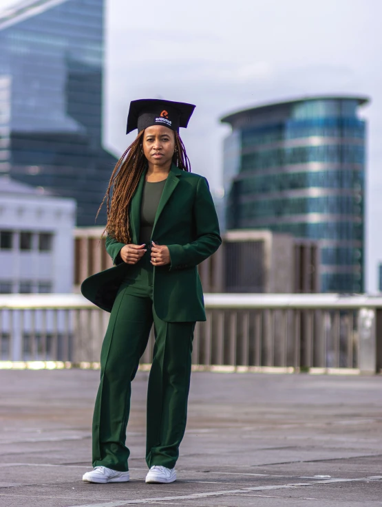 a woman wearing a green suit and mortarer