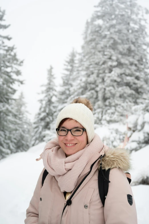 a woman with glasses standing on top of snow covered ground