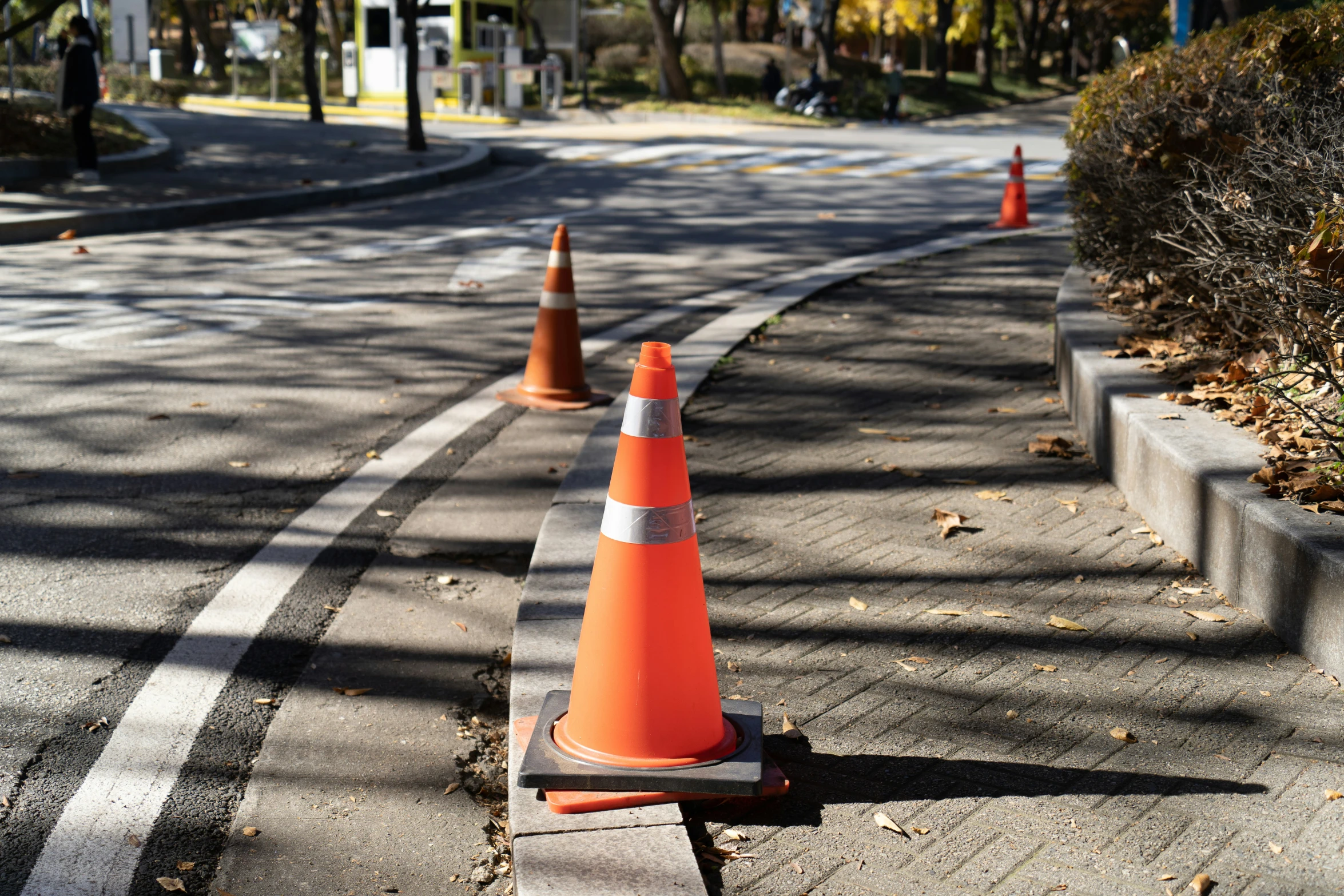 two orange traffic cones on the street near a road