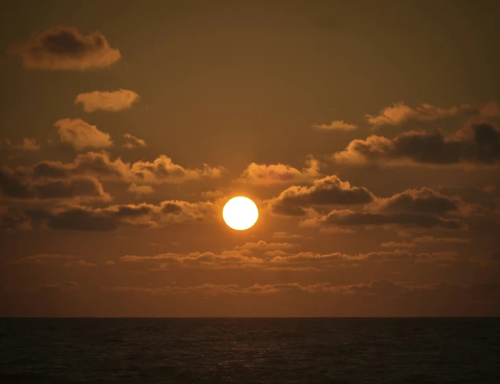 a plane flying in the sky over the ocean