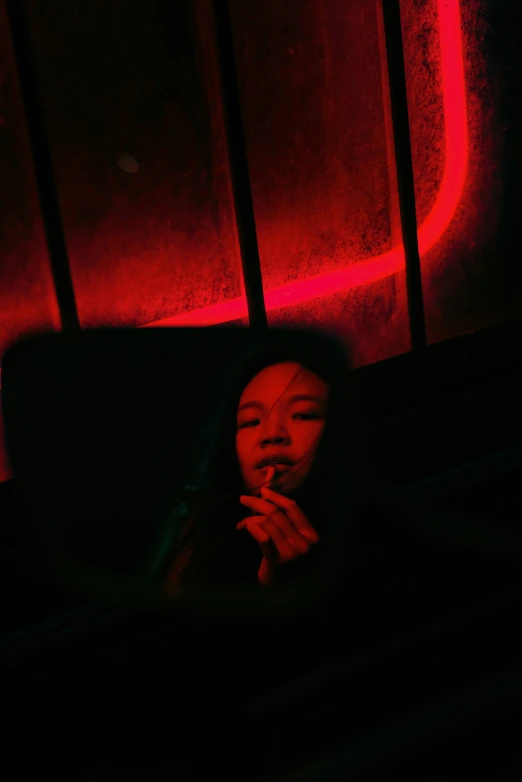 a girl holding her hands together in a dark room