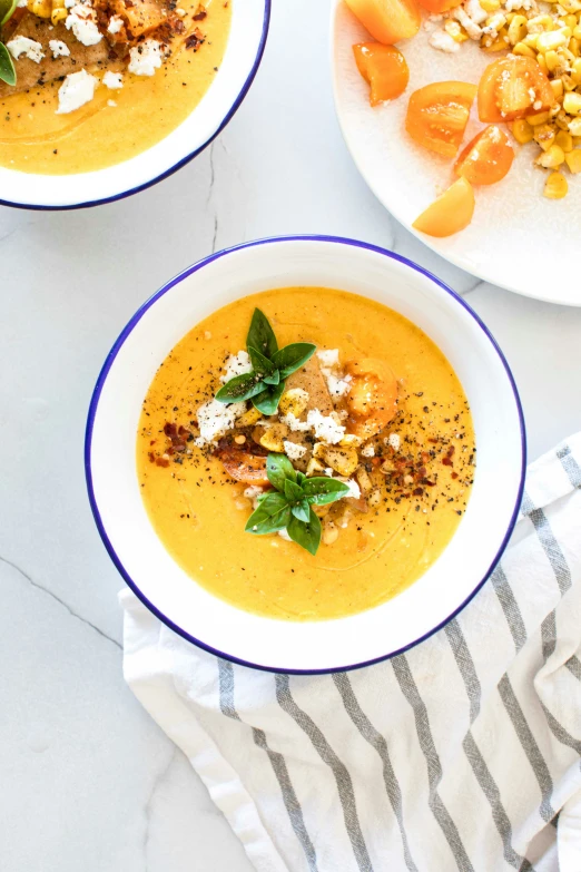 two bowls of soup are sitting on a marble table