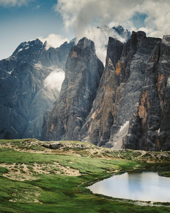 the mountains with snow and cloud have grass on them