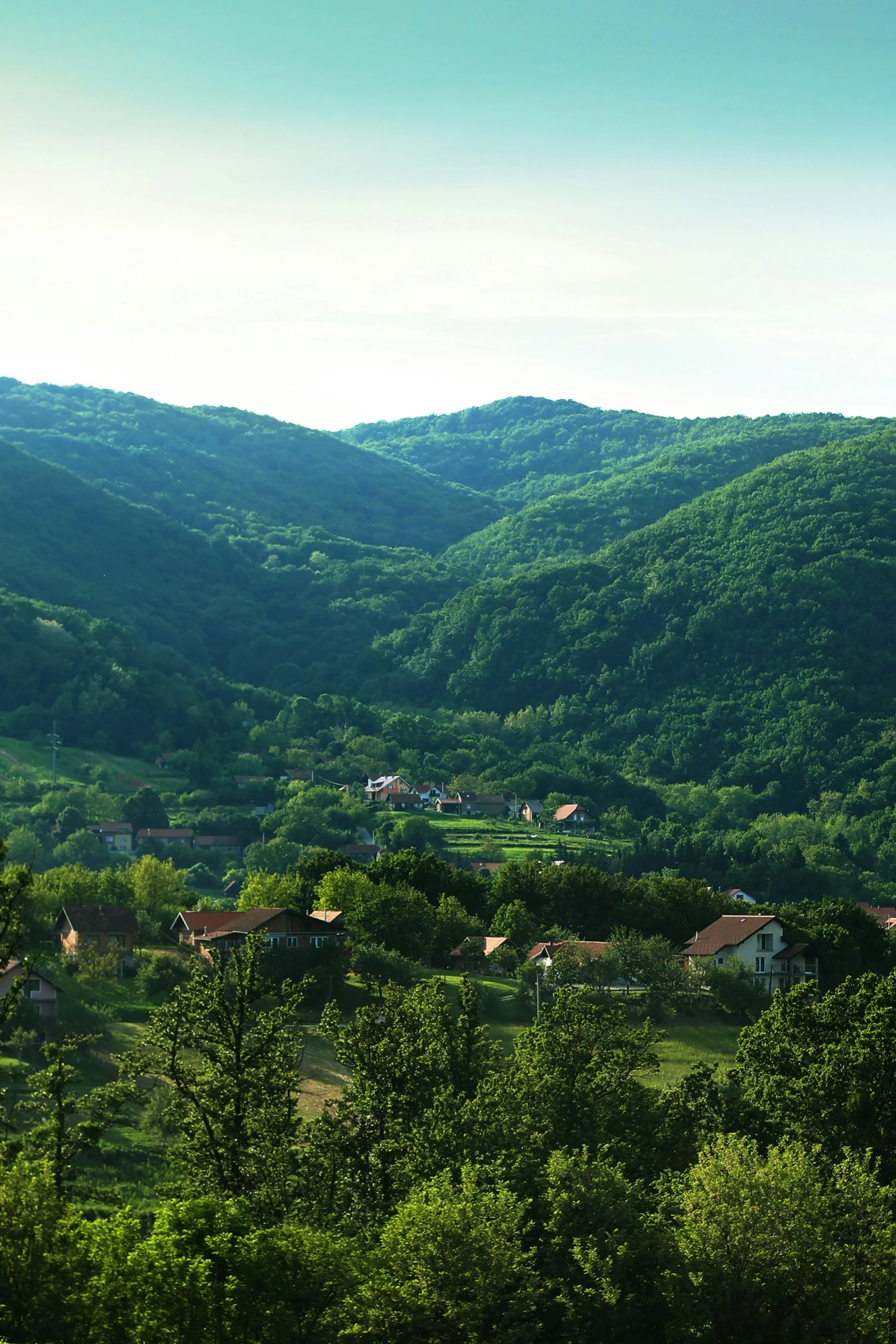 green mountains are seen near houses in the valley