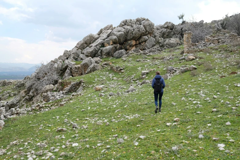 person hiking uphill on a cloudy day