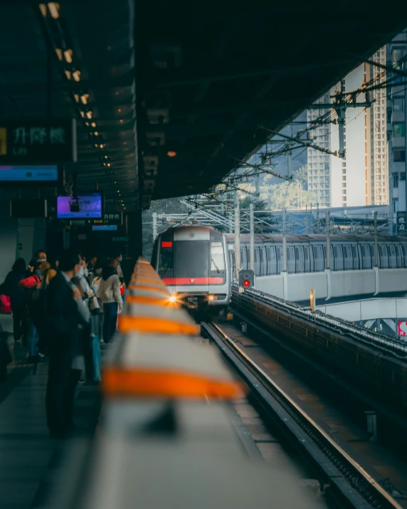 a crowd of people standing at a train station next to a subway