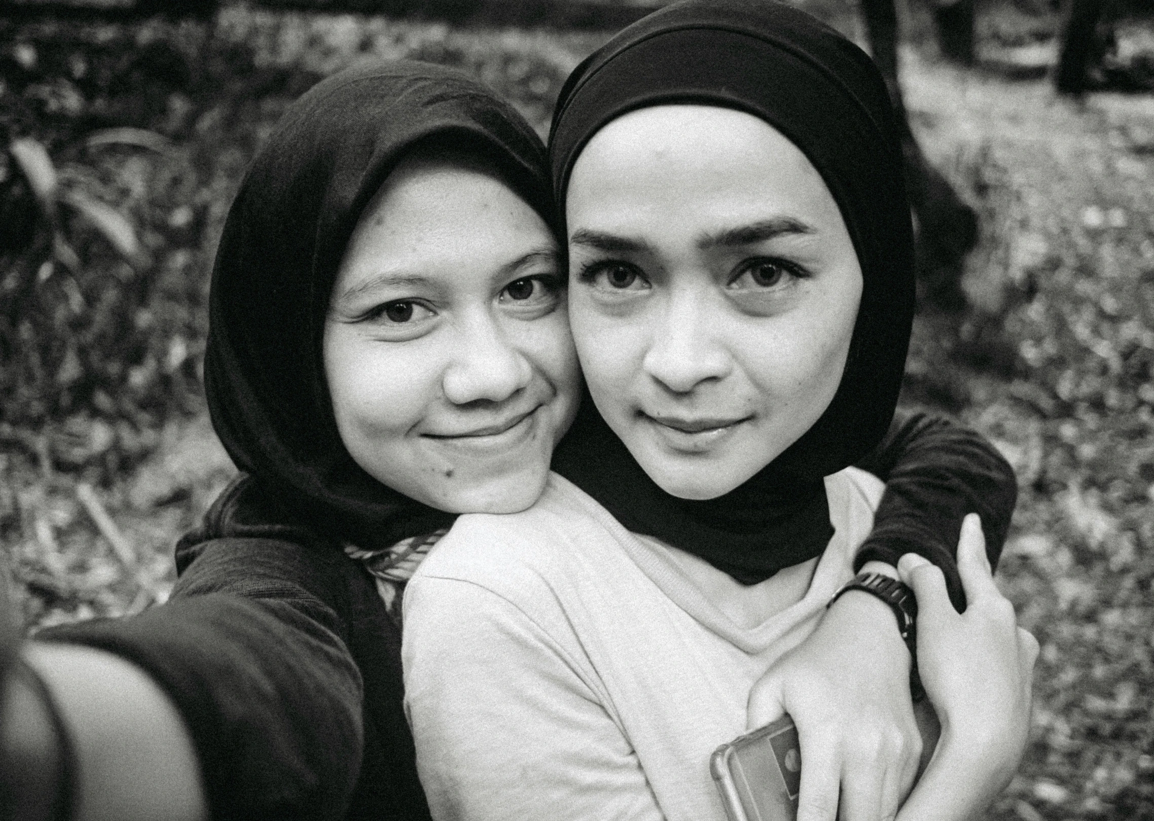 two women taking pictures with their cell phones