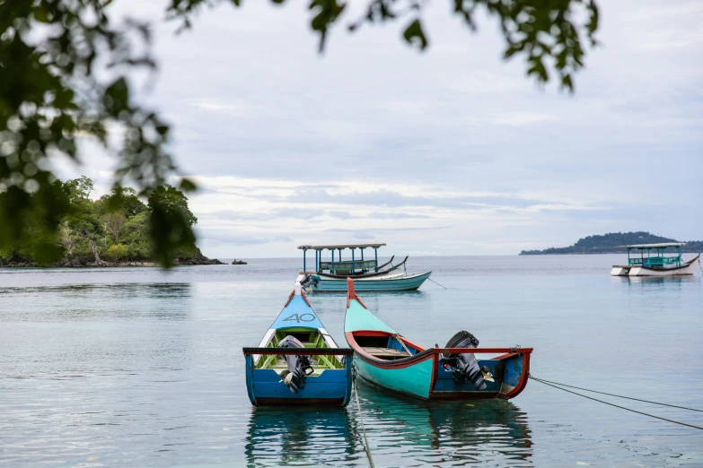 several colorful boats are docked by some shore