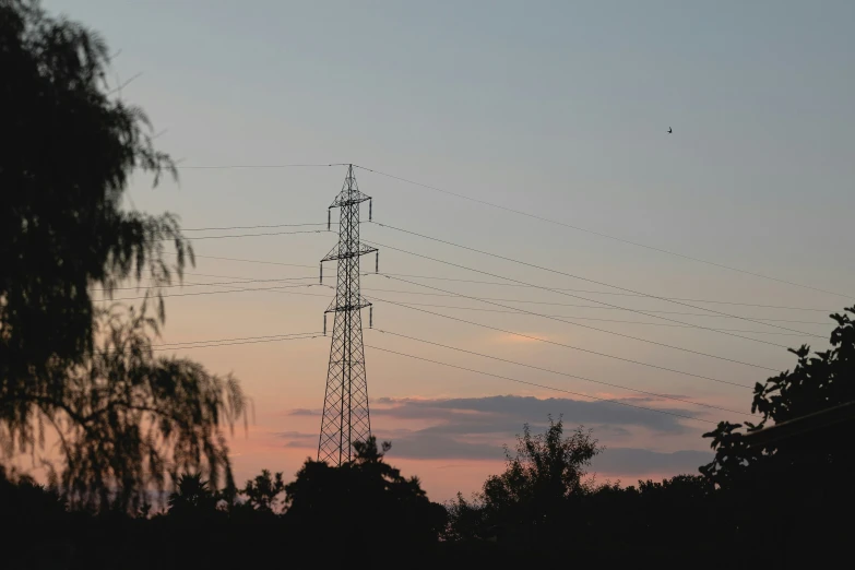 telephone towers are silhouetted against the setting sun