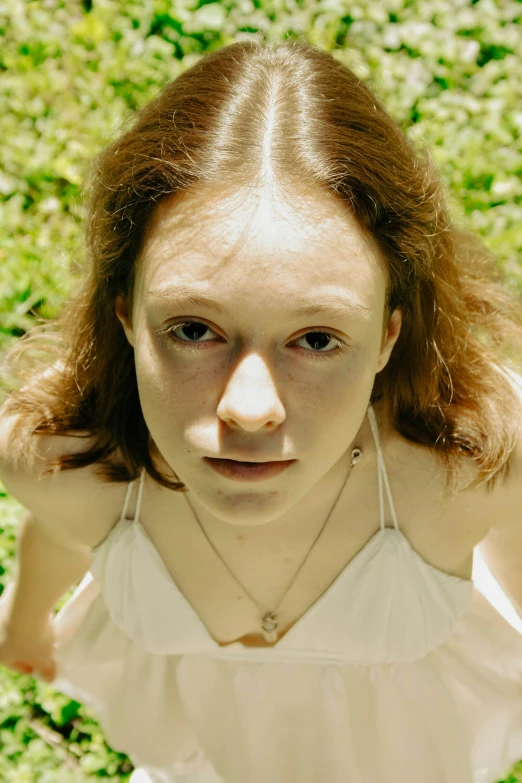 a girl in a white top has her hair up