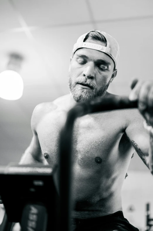 man in a cap lifting a heavy barbell